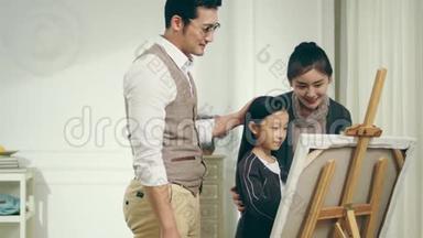 亚洲爸爸妈妈看着帮女儿画画